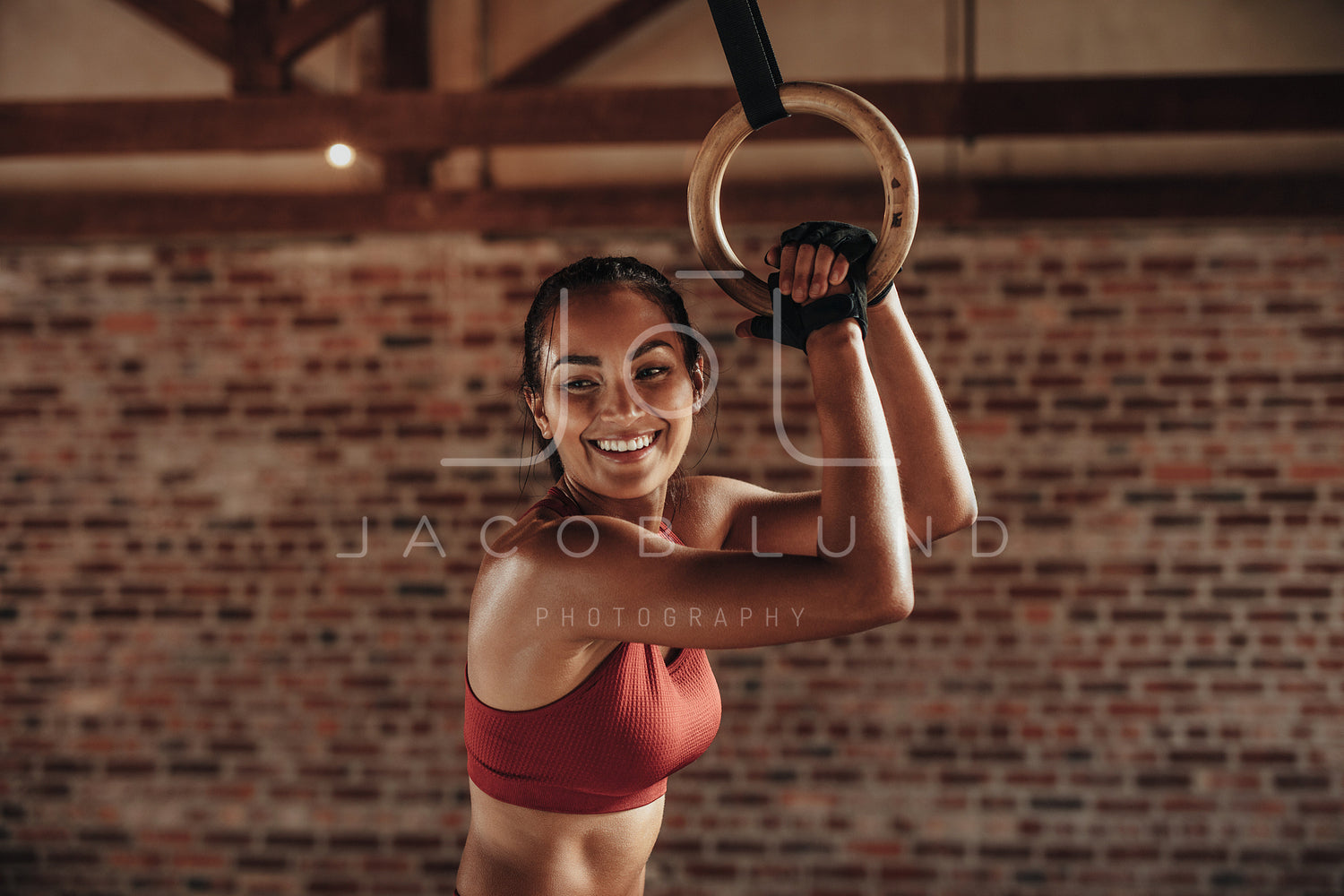 Fit woman holding gymnast rings at the gym – Jacob Lund
